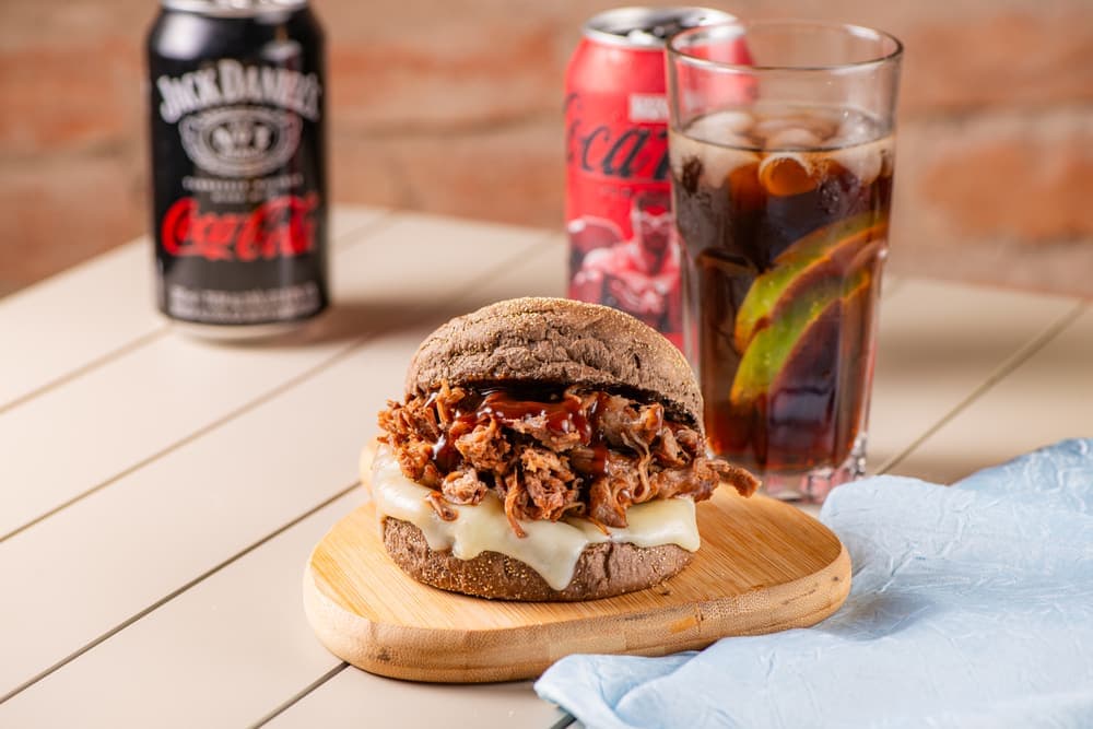 Hambúrguer de carne desfiada no pão australiano, com refrigerante.