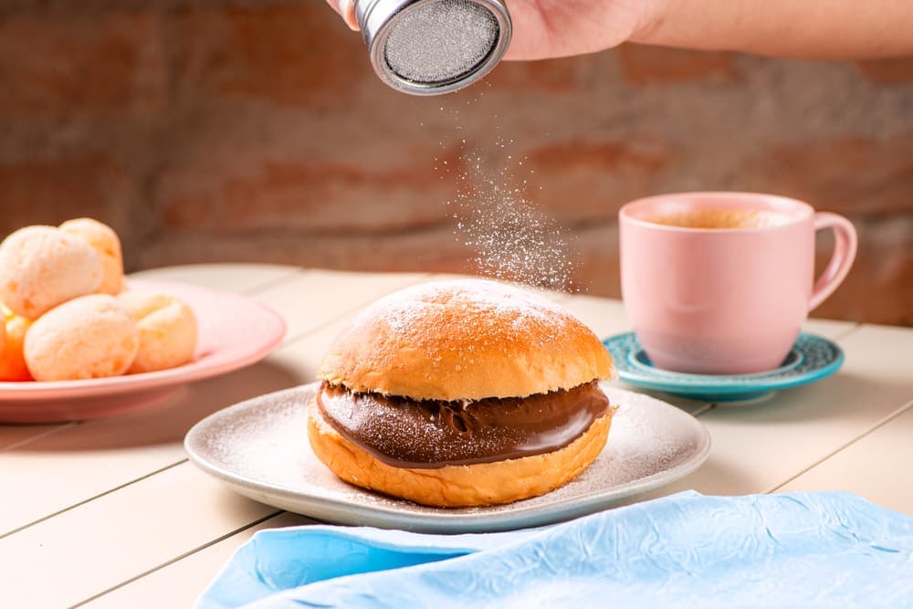 Sonho de chocolate em prato azul, com café.