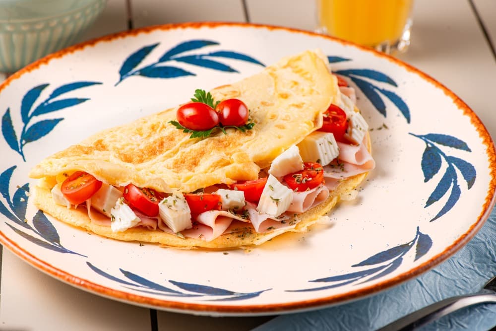 Omelete de tomate e queijo em prato azul.