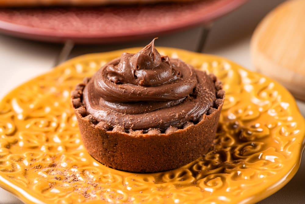 Tortinha de brigadeiro em prato amarelo.