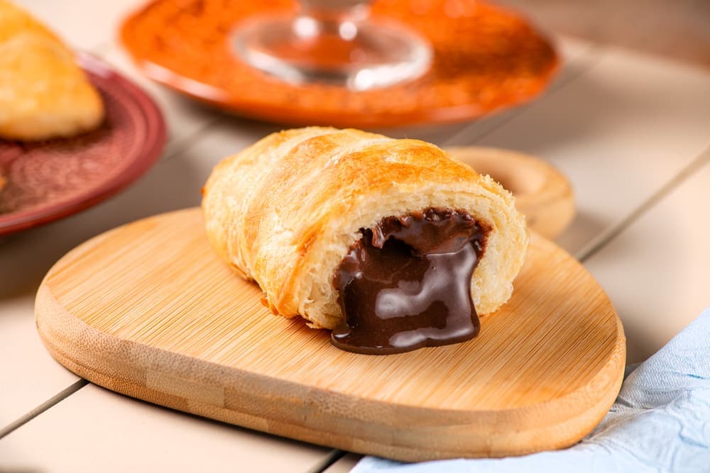 Croissant recheado de chocolate na tábua.