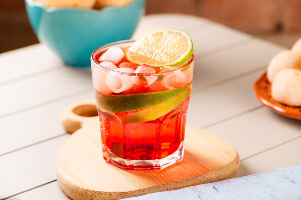 Suco de morango com limão em copo, com pães de queijo.