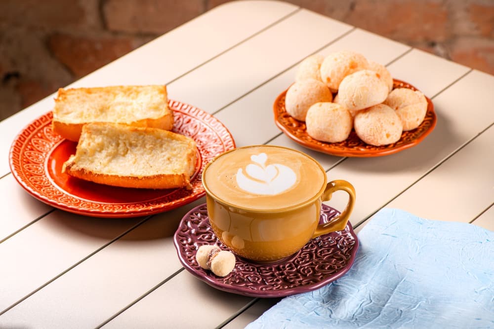 Pão na chapa com cappuccino e pães de queijo.