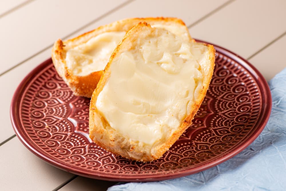 Pão francês na chapa com manteiga e café com leite.